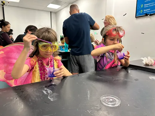 Two girls in fairy costumes make slime